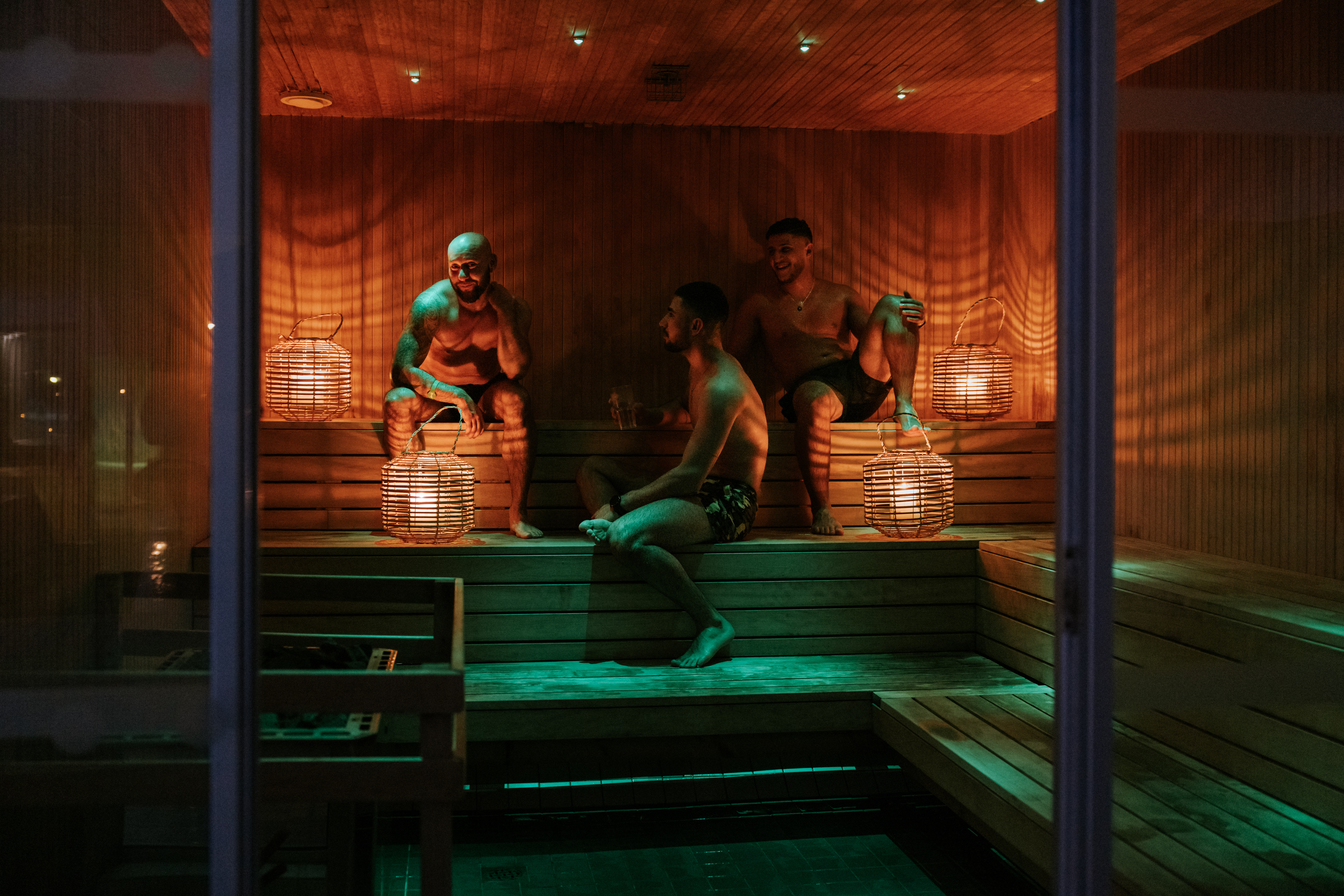Guests relaxing in a wood-lined sauna at Tromsøbadet.